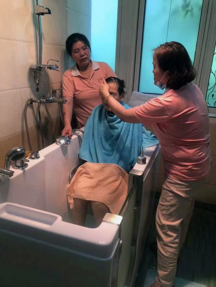 图为专业人员助浴